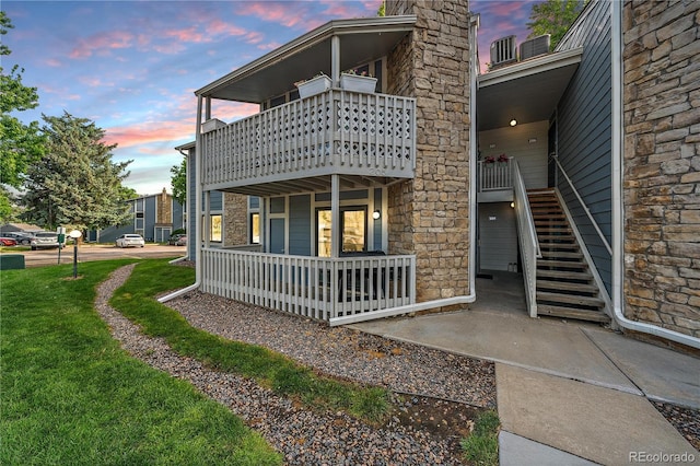 8335 Fairmount Dr Unit 2-105, Denver, CO 80247 - rear view of property with a balcony, covered porch, a yard, and stairway