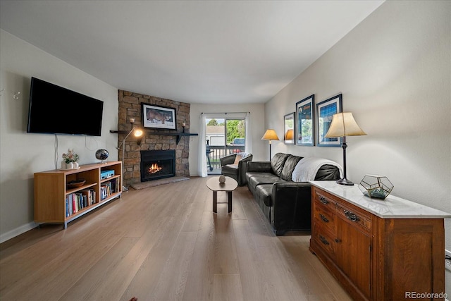 8335 Fairmount Dr Unit 2-105, Denver, CO 80247 - living room with light wood-style floors, a stone fireplace, and baseboards
