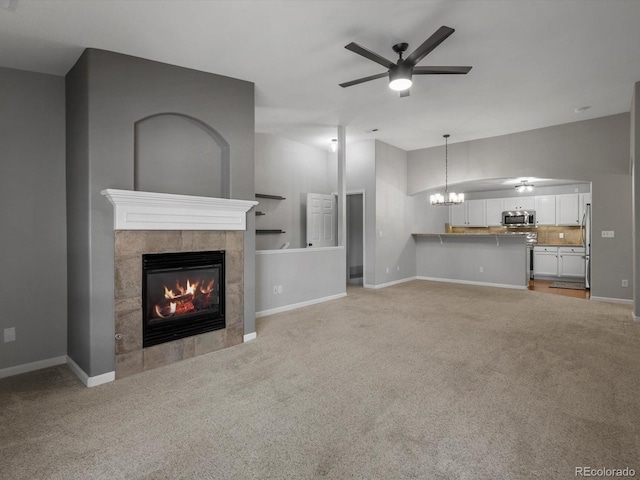 7131 S Wenatchee Way Unit C, Aurora, CO 80016 - unfurnished living room featuring light colored carpet, a fireplace, ceiling fan, and a chandelier