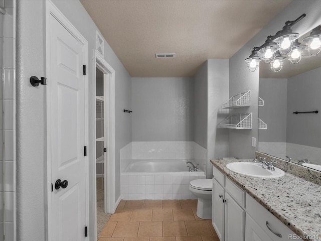 7131 S Wenatchee Way Unit C, Aurora, CO 80016 - bathroom with vanity, a bath, tile patterned flooring, a walk in closet, and a textured ceiling