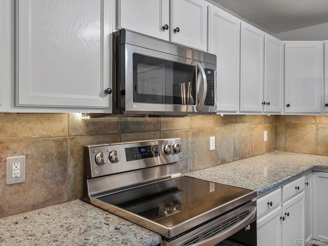7131 S Wenatchee Way Unit C, Aurora, CO 80016 - kitchen featuring appliances with stainless steel finishes, white cabinetry, tasteful backsplash, and light stone counters