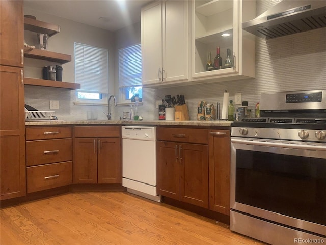 kitchen featuring tasteful backsplash, sink, wall chimney range hood, dishwasher, and stainless steel stove