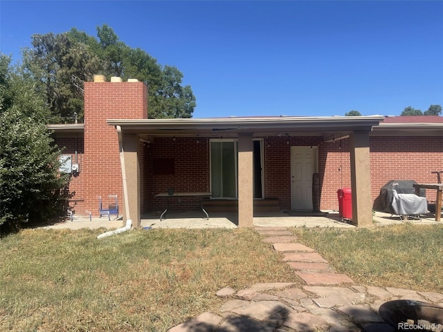 rear view of house with ceiling fan and a yard