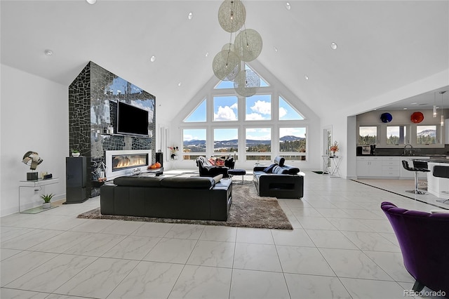 living room with sink, high vaulted ceiling, and a tiled fireplace