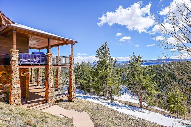 snowy yard featuring a deck with mountain view