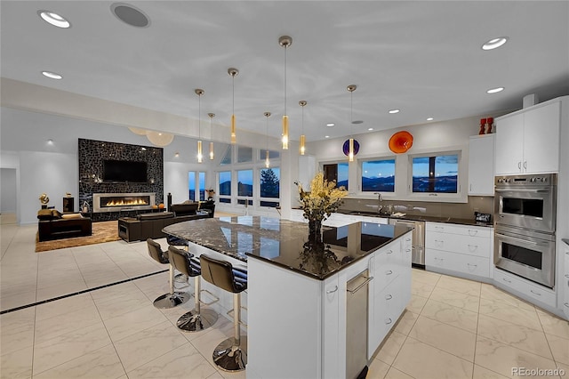 kitchen featuring a center island, pendant lighting, white cabinets, and stainless steel appliances