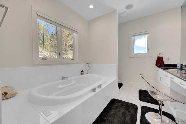 bathroom with a wealth of natural light and tiled bath