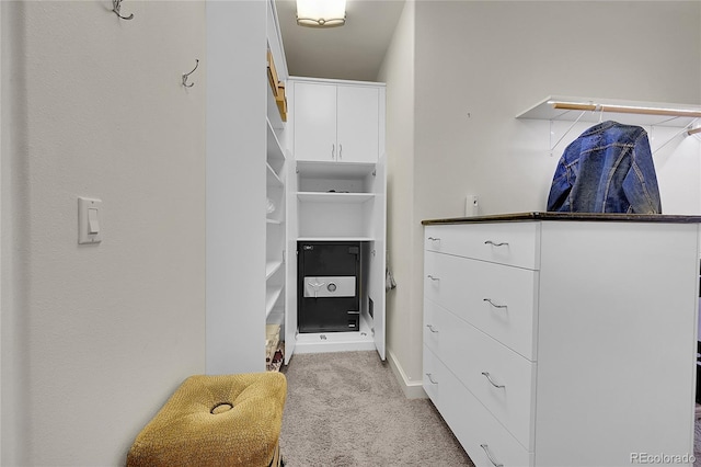 walk in closet featuring light colored carpet