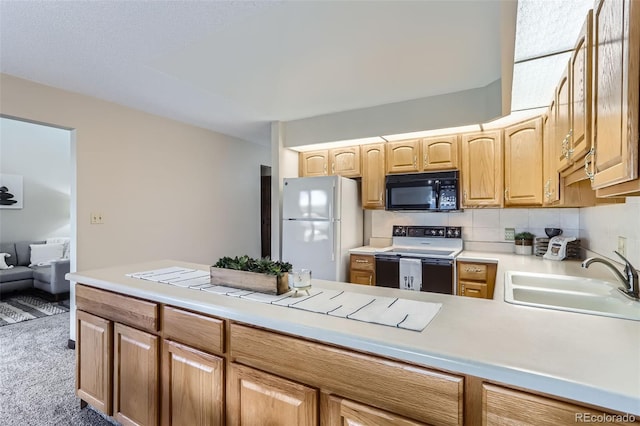 kitchen with electric stove, light countertops, freestanding refrigerator, a sink, and black microwave