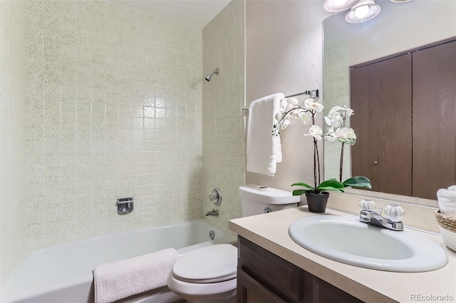 full bath with toilet, vanity, tub / shower combination, and a textured wall