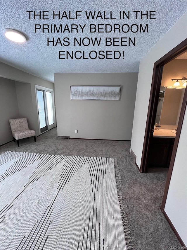 carpeted empty room with a sink, baseboards, and a textured ceiling