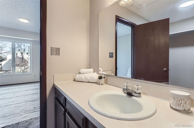 bathroom with vanity, a textured ceiling, and wood finished floors