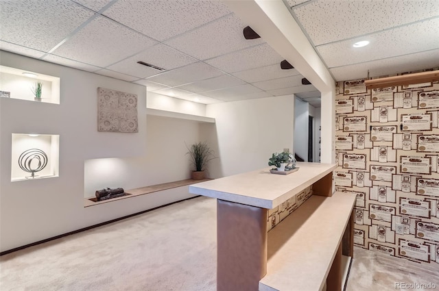 interior space featuring light colored carpet and a drop ceiling