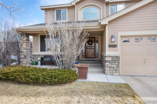 doorway to property featuring a garage and a porch