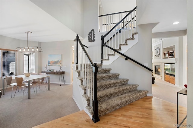 stairway featuring hardwood / wood-style flooring and a towering ceiling