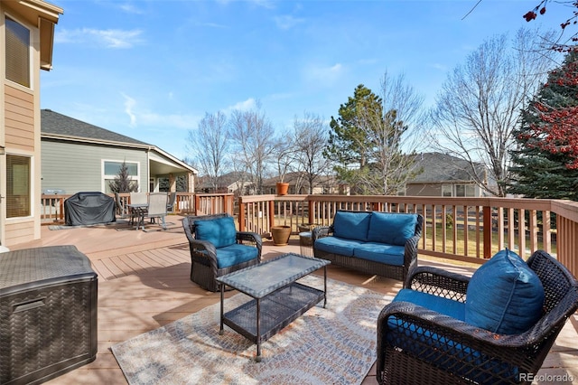 wooden deck with area for grilling and an outdoor hangout area