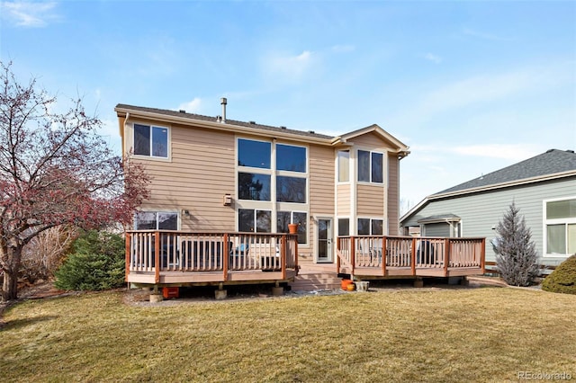 back of property with a wooden deck and a lawn