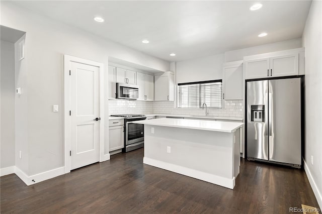 3820 N Olive St Unit 2, Denver, CO 80207 - kitchen featuring stainless steel appliances, light countertops, backsplash, a center island, and dark wood-style flooring