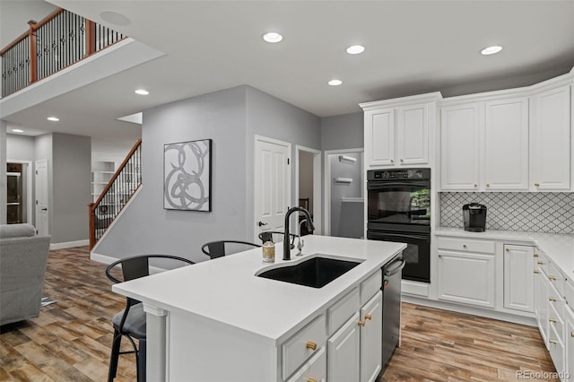 24682 E Ontario Dr, Aurora, CO 80016 - kitchen featuring a sink, light wood-style floors, recessed lighting, tasteful backsplash, and white cabinetry
