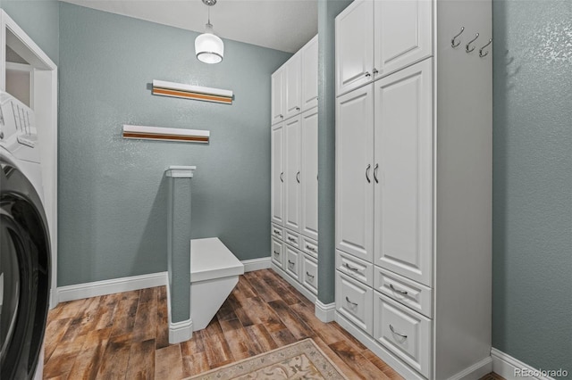 24682 E Ontario Dr, Aurora, CO 80016 - laundry room featuring cabinet space, baseboards, washer / dryer, dark wood-style flooring, and a textured wall