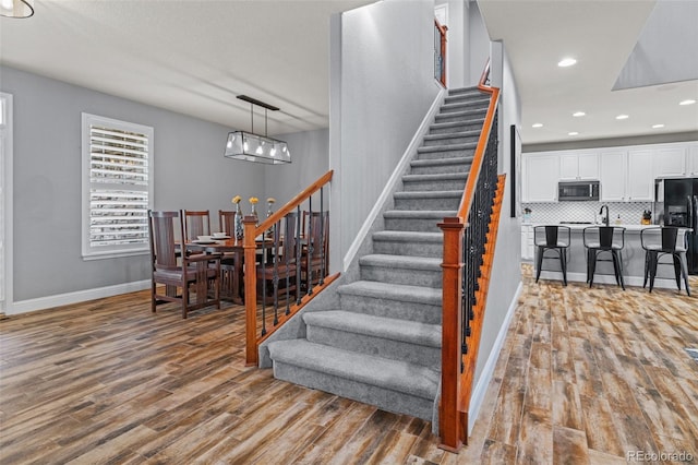 24682 E Ontario Dr, Aurora, CO 80016 - stairway featuring wood finished floors, baseboards, and recessed lighting