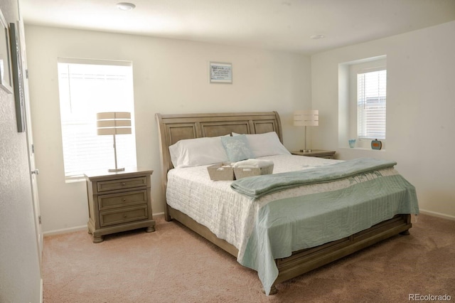 bedroom featuring baseboards and light colored carpet