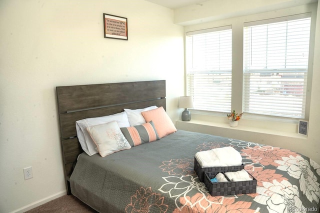 bedroom featuring carpet floors, baseboards, and multiple windows