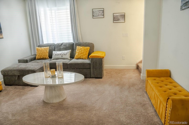 living area featuring carpet floors, baseboards, and stairs