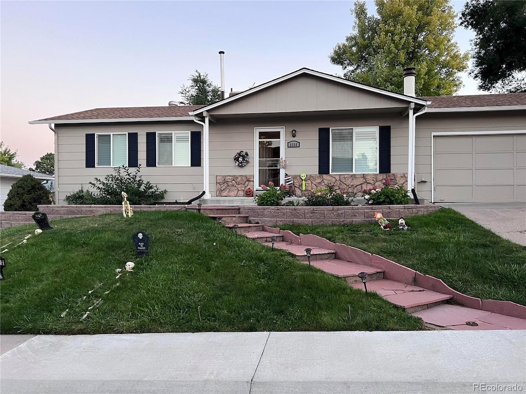 ranch-style home with a lawn and a garage