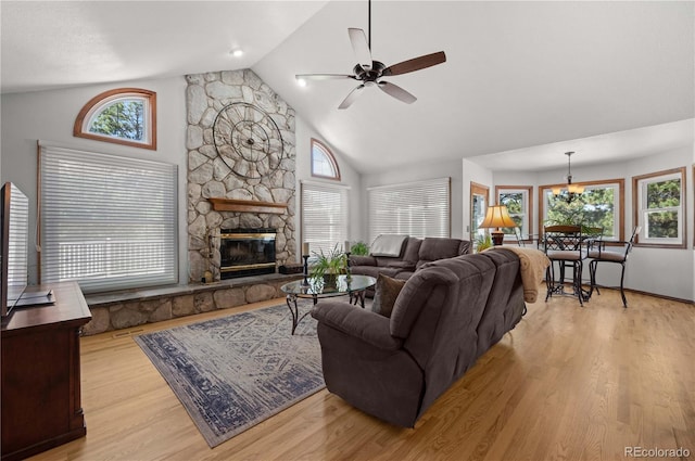 17815 Saddlewood, Monument, CO 80132 - living room featuring light wood-type flooring, a ceiling fan, a stone fireplace, and high vaulted ceiling