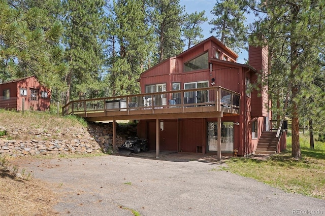 rear view of house featuring a wooden deck