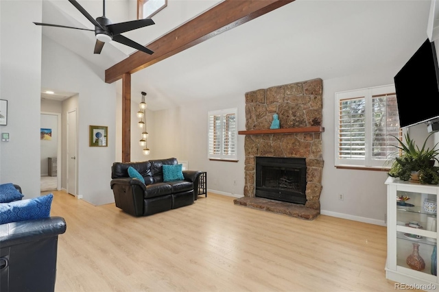 living room with ceiling fan, high vaulted ceiling, a fireplace, beamed ceiling, and light wood-type flooring