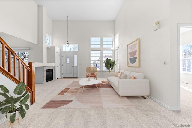 carpeted living room with a towering ceiling and a fireplace