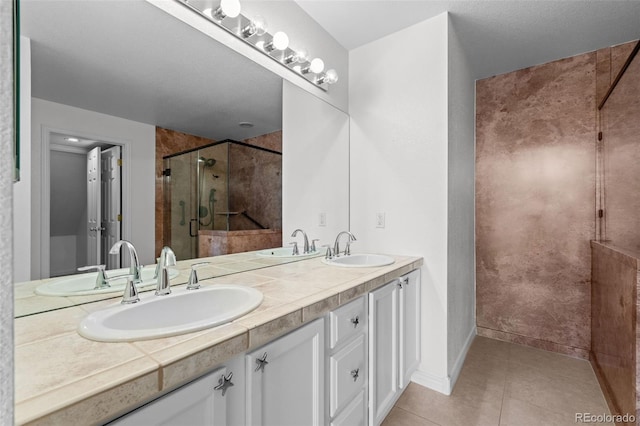 bathroom with tile patterned flooring, vanity, and walk in shower