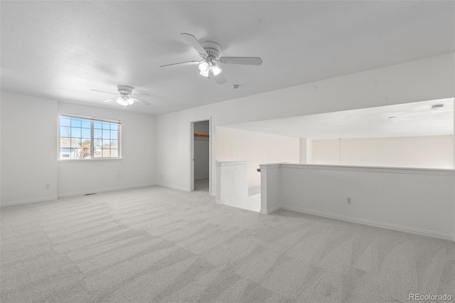 spare room with light colored carpet and ceiling fan