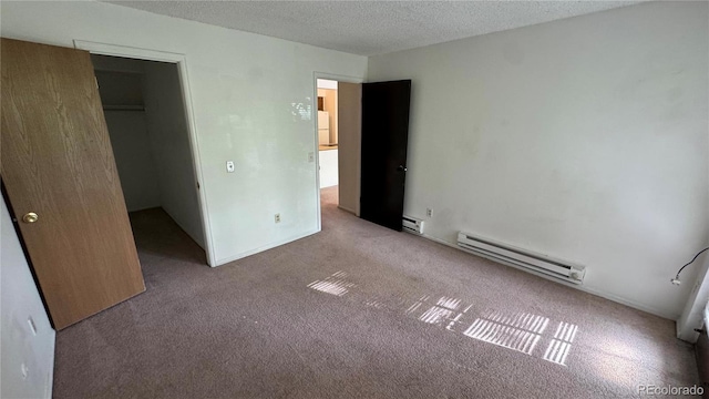 unfurnished bedroom featuring a textured ceiling, light colored carpet, baseboard heating, and a closet