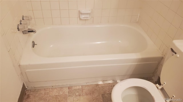 bathroom featuring a tub to relax in and toilet