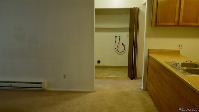 interior space featuring sink, light carpet, and a baseboard heating unit