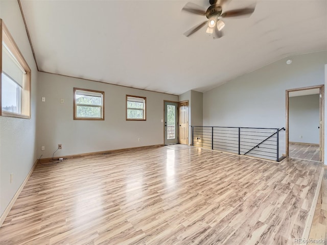 unfurnished room featuring ceiling fan, vaulted ceiling, light hardwood / wood-style floors, and a healthy amount of sunlight