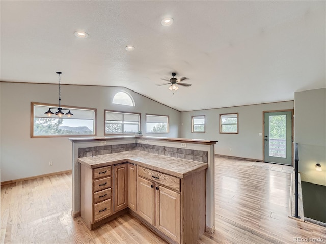 kitchen with ceiling fan, decorative light fixtures, light hardwood / wood-style flooring, and lofted ceiling