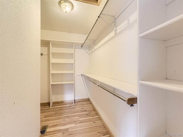 spacious closet featuring light hardwood / wood-style floors