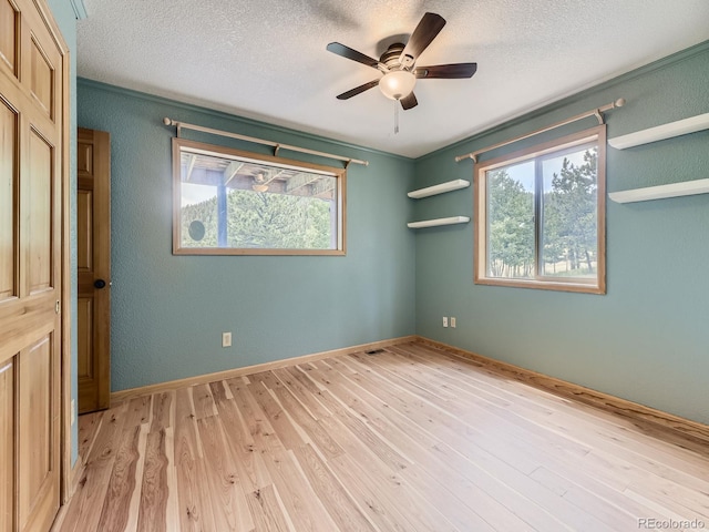 spare room with ceiling fan, a textured ceiling, and light hardwood / wood-style flooring