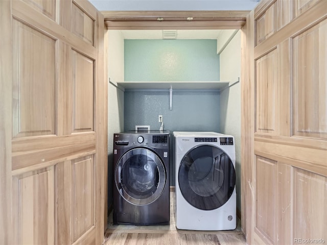 laundry room featuring light hardwood / wood-style flooring and washing machine and dryer