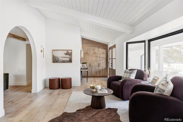 living room featuring vaulted ceiling with beams and light wood-type flooring