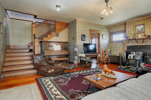 living room with hardwood / wood-style floors, a notable chandelier, and crown molding