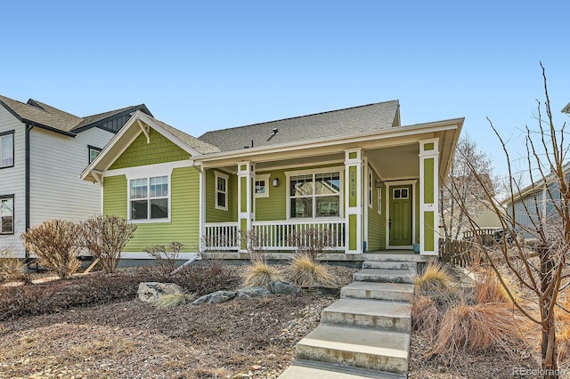 view of front of house with covered porch and a shingled roof