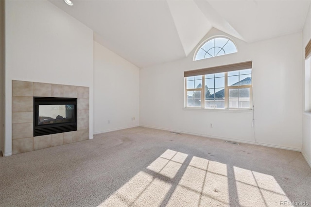 unfurnished living room with light colored carpet, a fireplace, and high vaulted ceiling