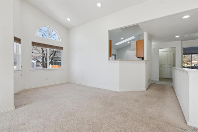 unfurnished living room featuring a wealth of natural light and light colored carpet