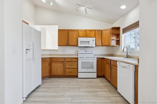 kitchen with vaulted ceiling, sink, and white appliances