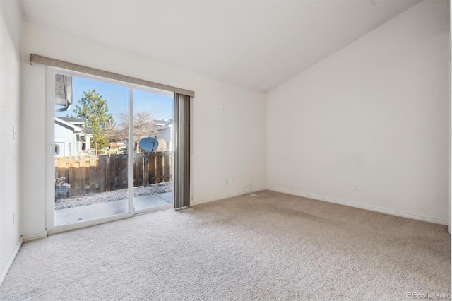 unfurnished room with carpet flooring and vaulted ceiling